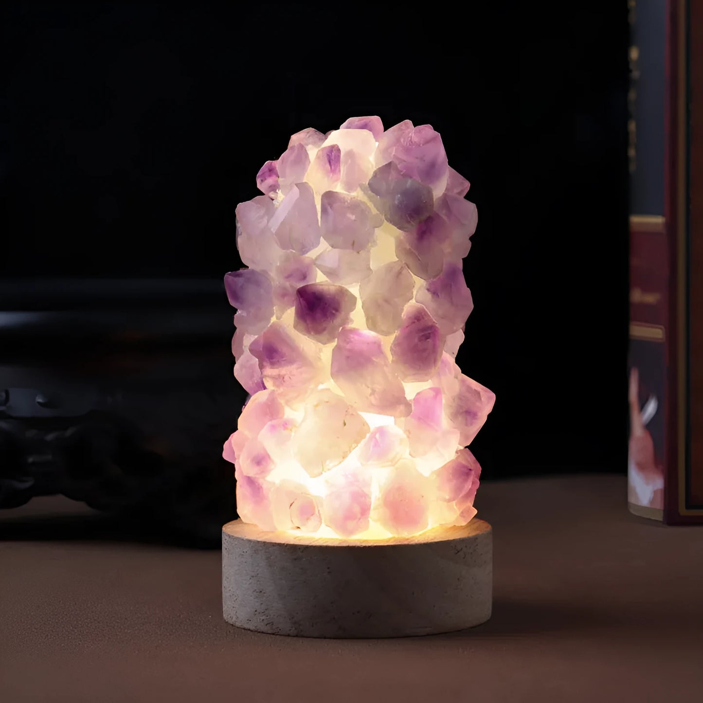Mini USB night light glowing inside a natural amethyst crystal vug geode on a dark surface.