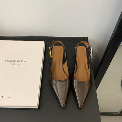 Women's black leather pointed toe shoes with low heel and thin strap.