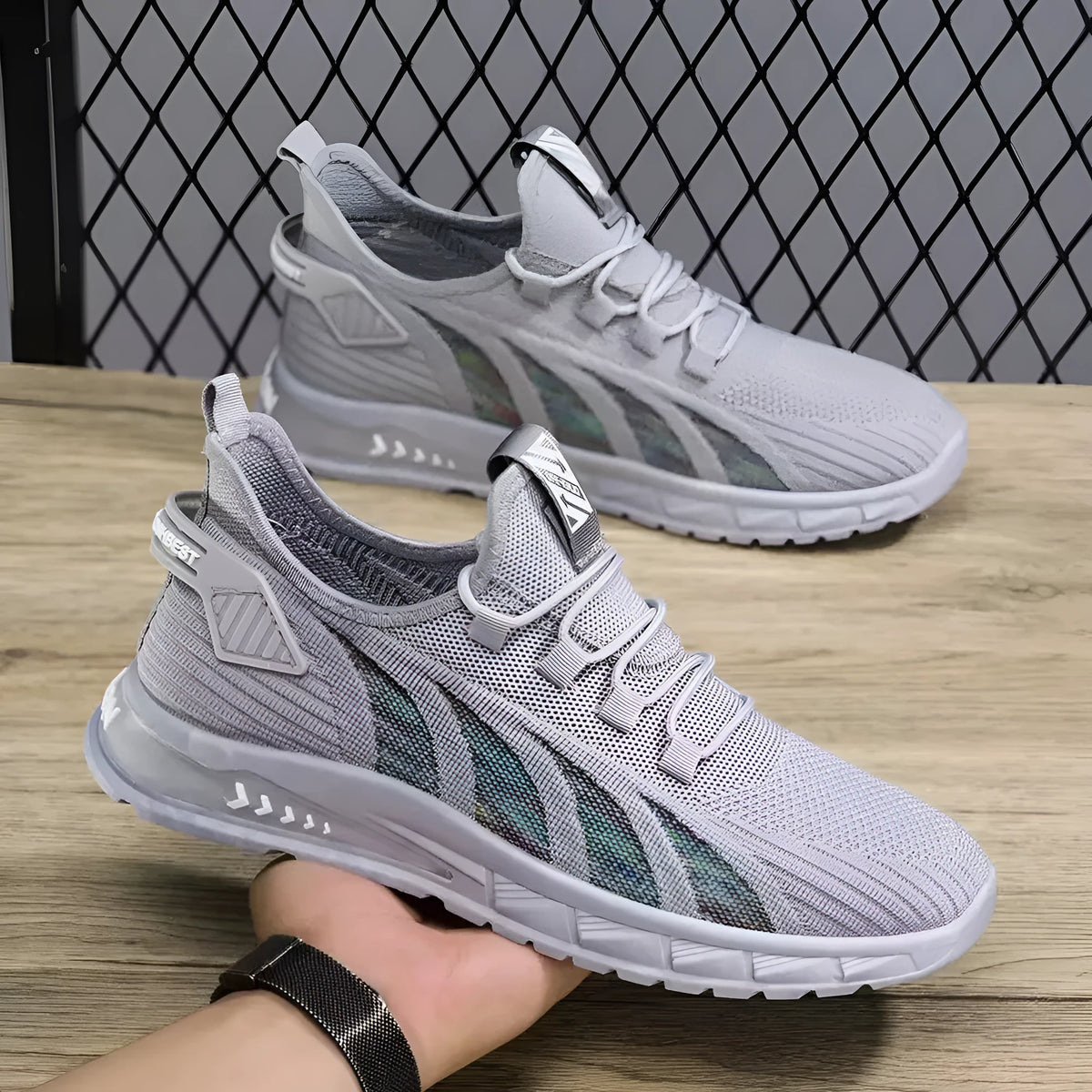 Low-top casual sneakers with striped mesh upper and flat plastic sole in grey colour.