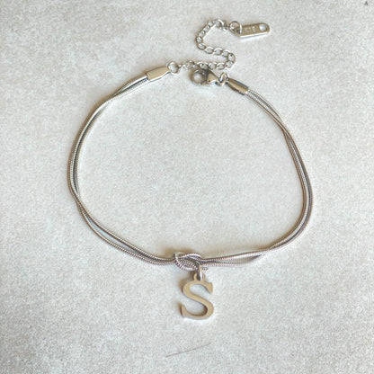 Elegant letter charm bracelets for women in gold and silver tones, featuring a delicate snake chain design and personalised letter charms.