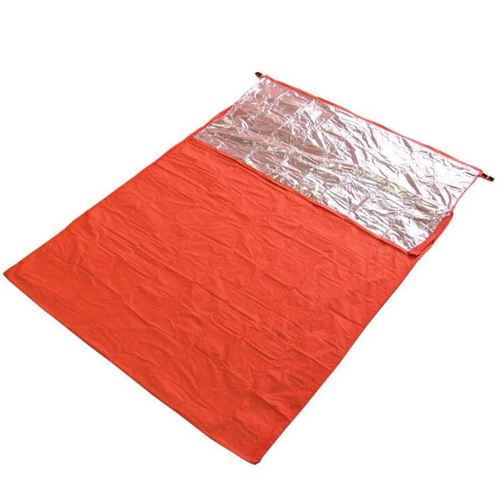 Orange outdoor thermal sleeping bag with silver coated nylon showing envelope design and storage bag