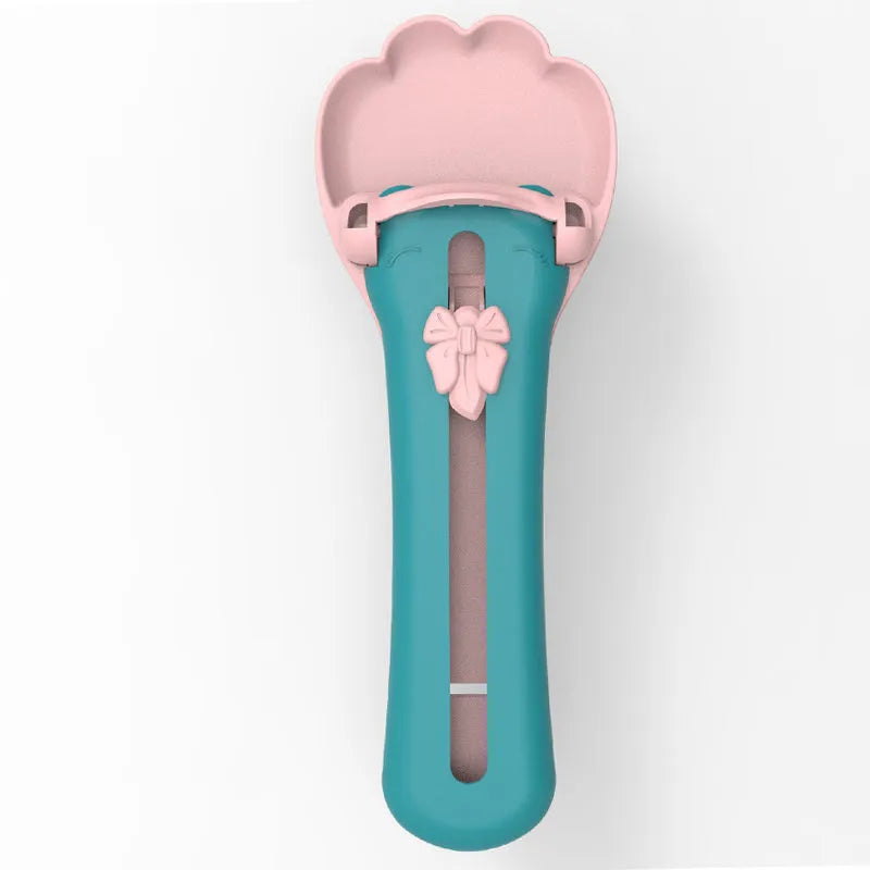 Green plastic pet food scoop with squeezer handle and dispensing nozzle for kibble and liquid.