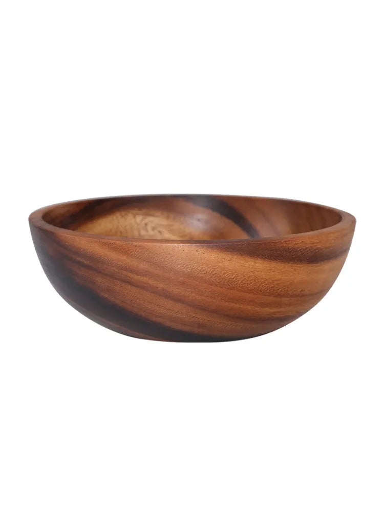 Set of five brown wooden bowls in different sizes on a wooden table, showing natural grain.