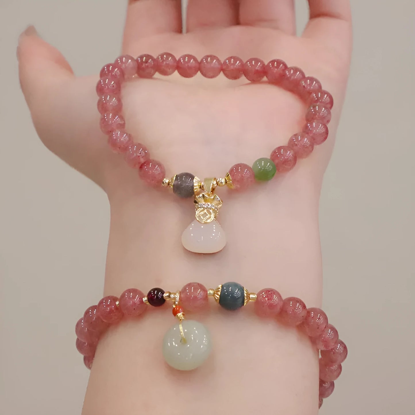 Natural strawberry quartz geometric bracelet with a small purse charm and silver safety buckle closure.