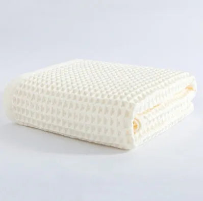 Large light-coloured cotton bath towel with a textured surface, measuring 140 by 70 centimetres.