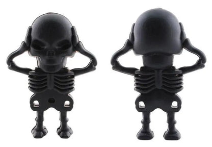 Skull-shaped black USB flash drive on a small metal keychain against a dark background.