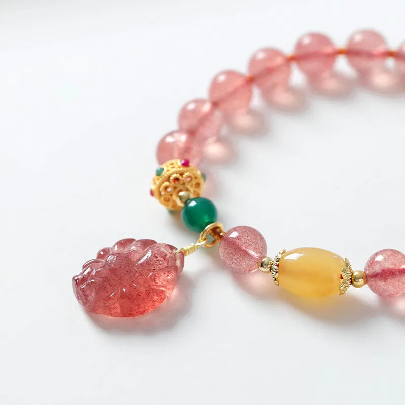 Women's strawberry quartz crystal beaded bracelet with Nine Tail Fox design on wrist