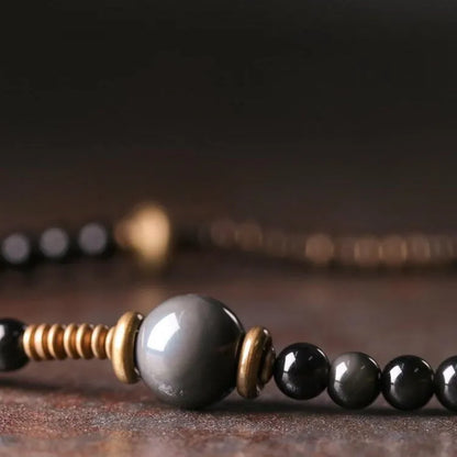 Black geometric beaded bracelet with multi-layered colourful design on wrist