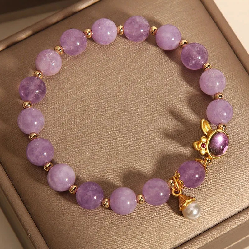 Natural mauve jade rabbit head charm bracelet with crystal details on wrist.
