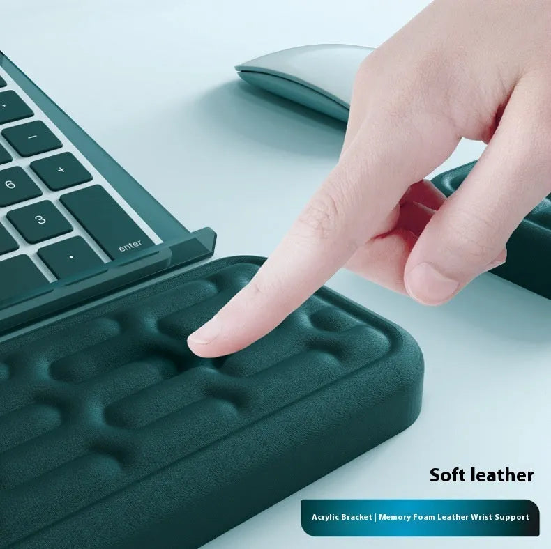 Double-sided black and grey keyboard mouse pad with wrist strap and hand pillow on a desk.