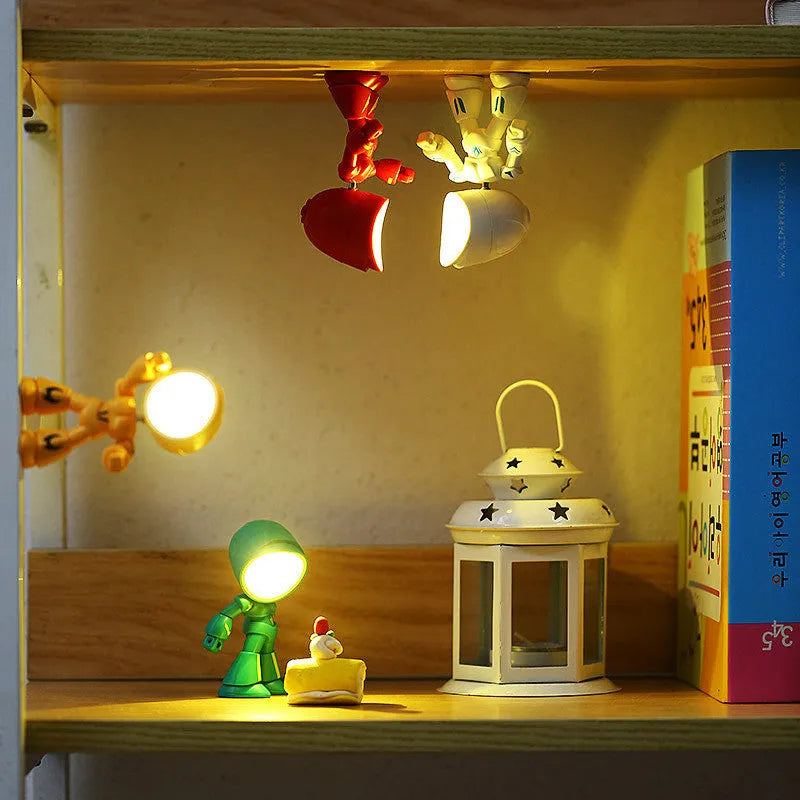 Mini mecha robot hero LED night light with adjustable arms on a desk.