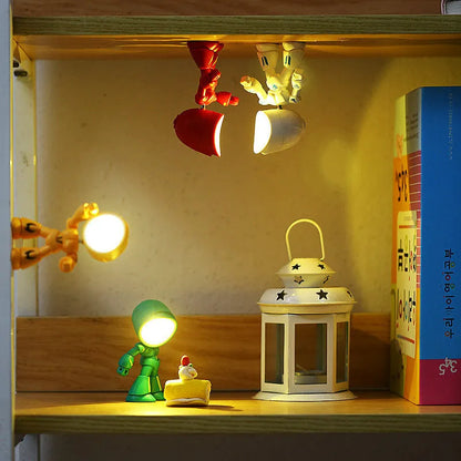 Mini mecha robot hero LED night light with adjustable arms on a desk.