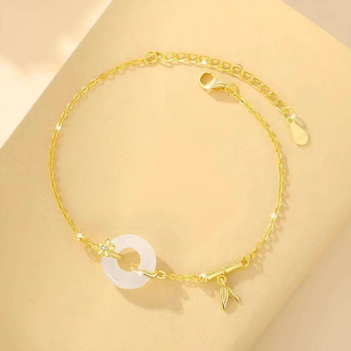 Women's silver and gold electroplated bracelet with peace buckle charm and white chalcedony stone.