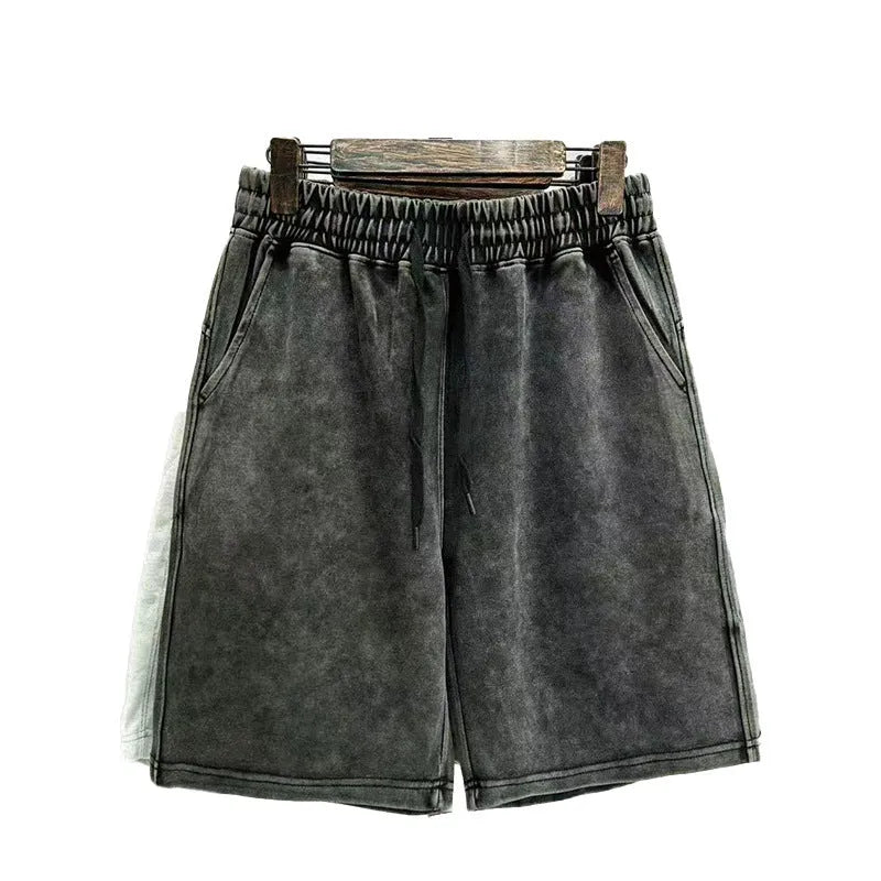 Man wearing loose-fit, straight-leg distressed cotton shorts in a solid colour