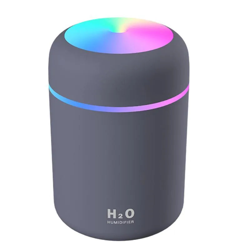 Pink USB desktop humidifier with LED lights and water tank on wooden desk