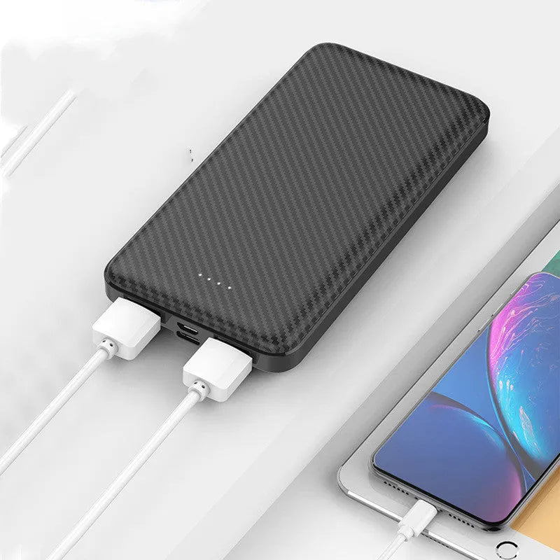 White portable power bank with 20000mAh capacity and multiple USB output ports on a table.