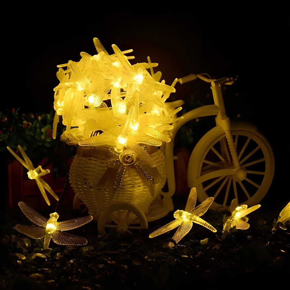 Solar-powered dragonfly string lights with 30 warm white LEDs in garden setting