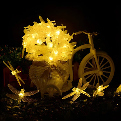 Solar-powered dragonfly string lights with 30 warm white LEDs in garden setting