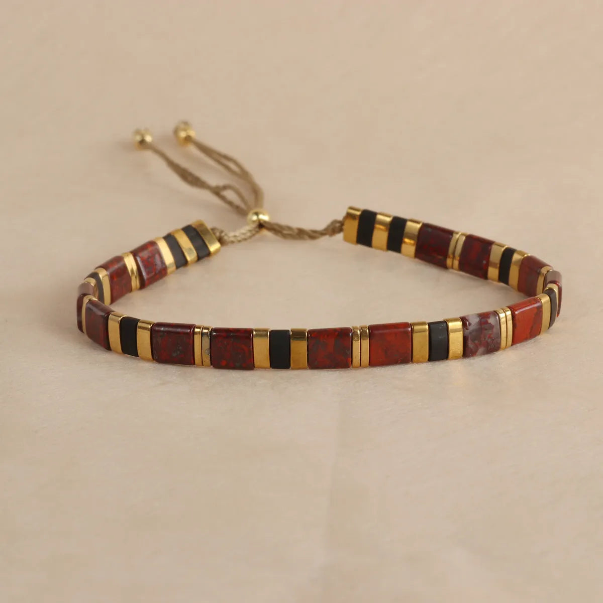 Geometric glass beaded pull bracelet in multiple colours including milky white, black, retro green, light blue, and red