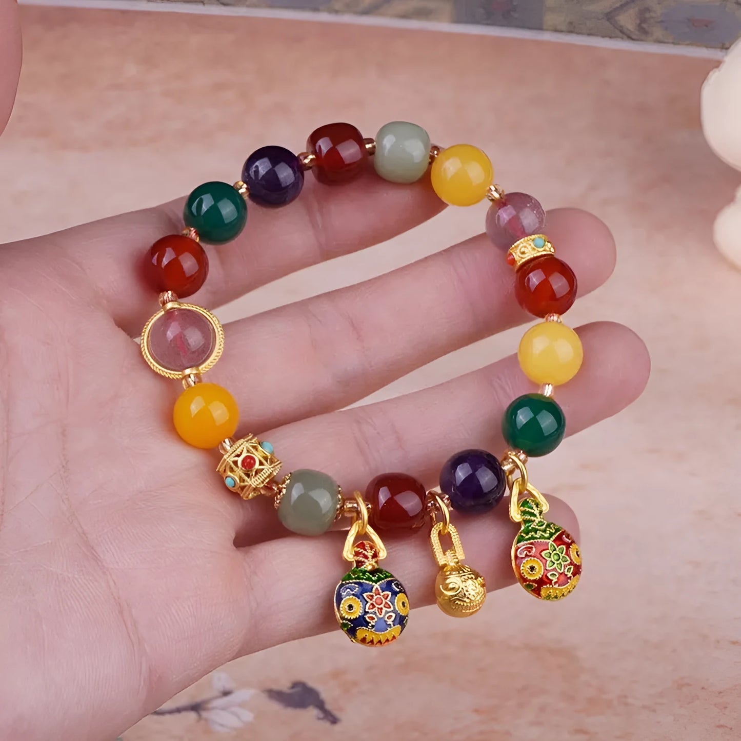 Hand-woven agate bracelet with 10mm beads and a detailed swallowing gold beast charm.
