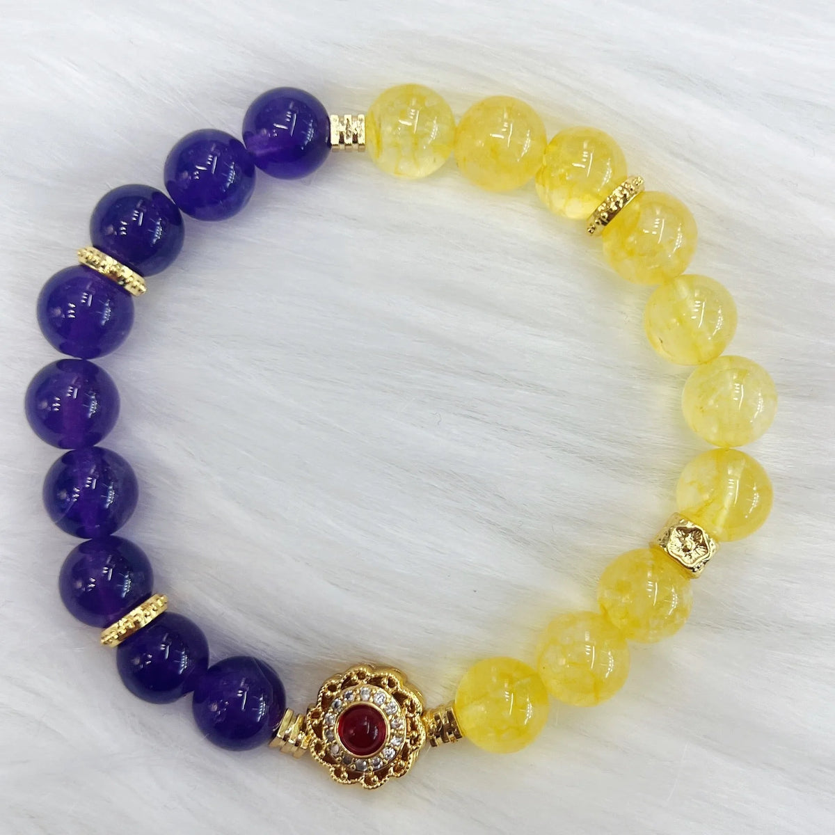 Handmade women's bracelet with yellow and purple amethyst crystals on wrist.