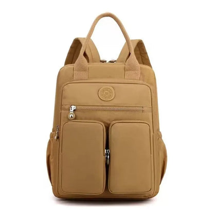 Women's waterproof nylon travel backpack in grey, showing front external pocket and organisational interior.