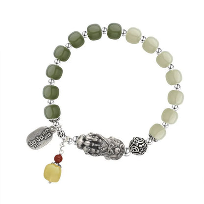Close-up of a retro-style sterling silver coin bracelet with natural Hetian jade beads for women.