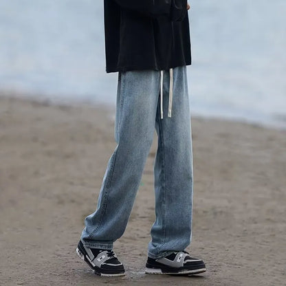 Men's blue straight-leg denim trousers with drawstring waist shown on hanger