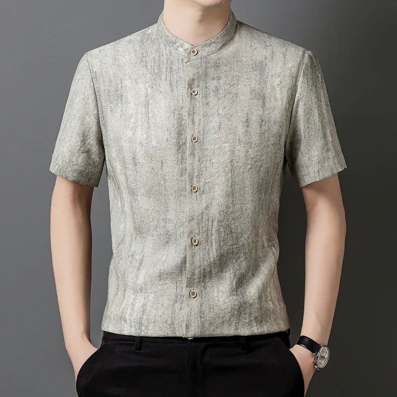 Man wearing a loose-fit grey linen blend short-sleeve shirt with a stand collar.