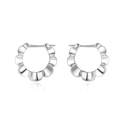 A pair of shiny silver geometric stud earrings with a round design on a plain background.