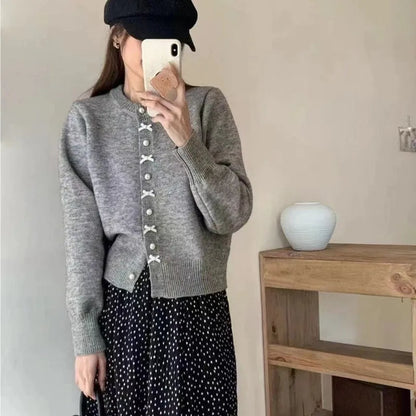 Women's acrylic cardigan sweater with pearl button bow detail in light yellow colour