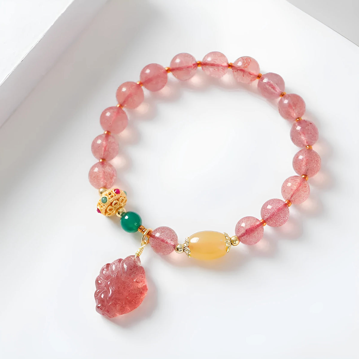 Women's strawberry quartz crystal beaded bracelet with Nine Tail Fox design on wrist