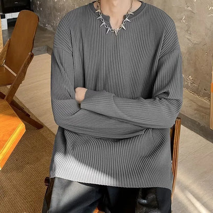 A woman wearing a black and white striped, loose-fit, long-sleeve pullover jumper.