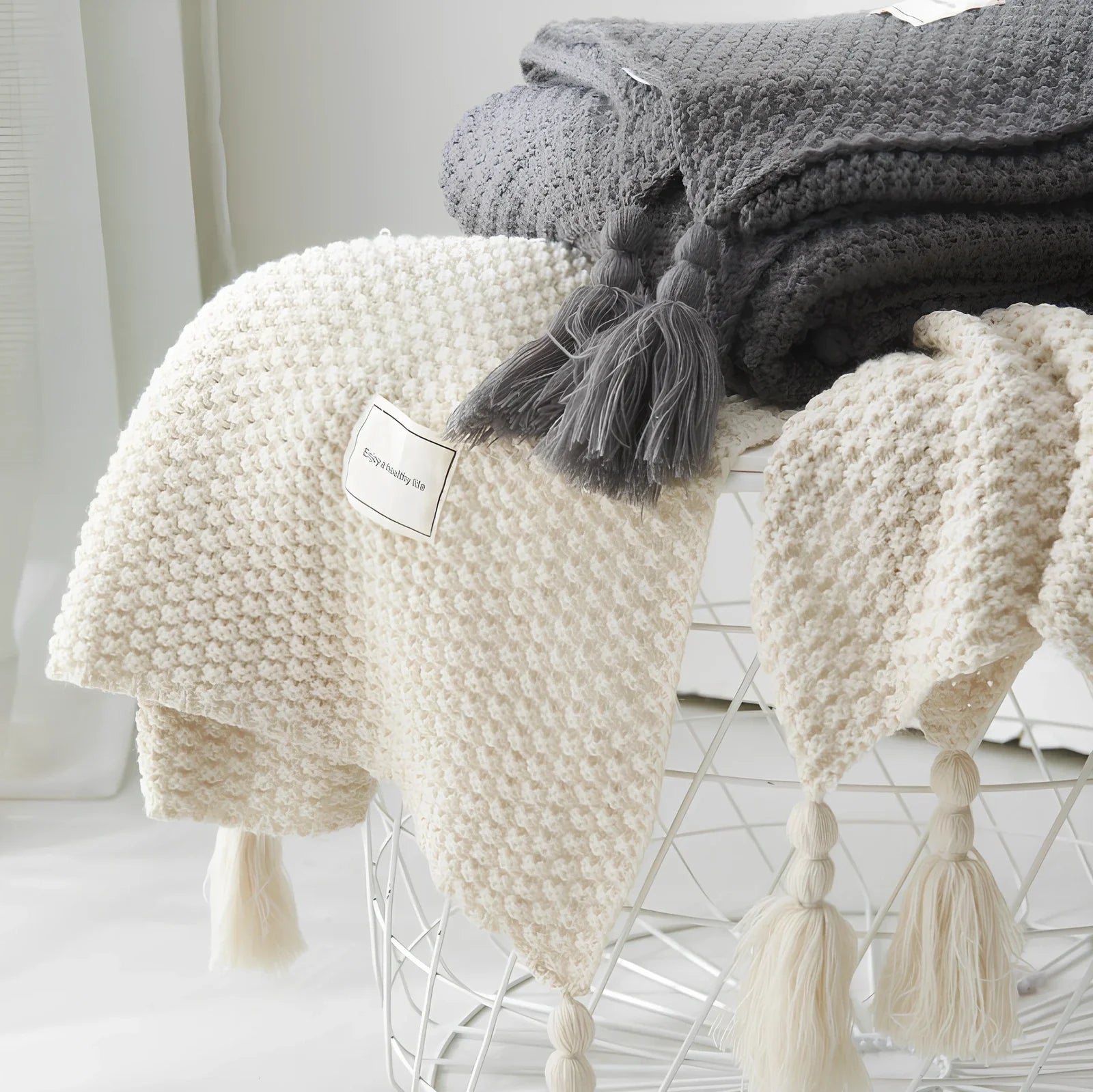 Fringed knitting blanket in beige colour showing 5cm fringe detailing and dense acrylic weave texture
