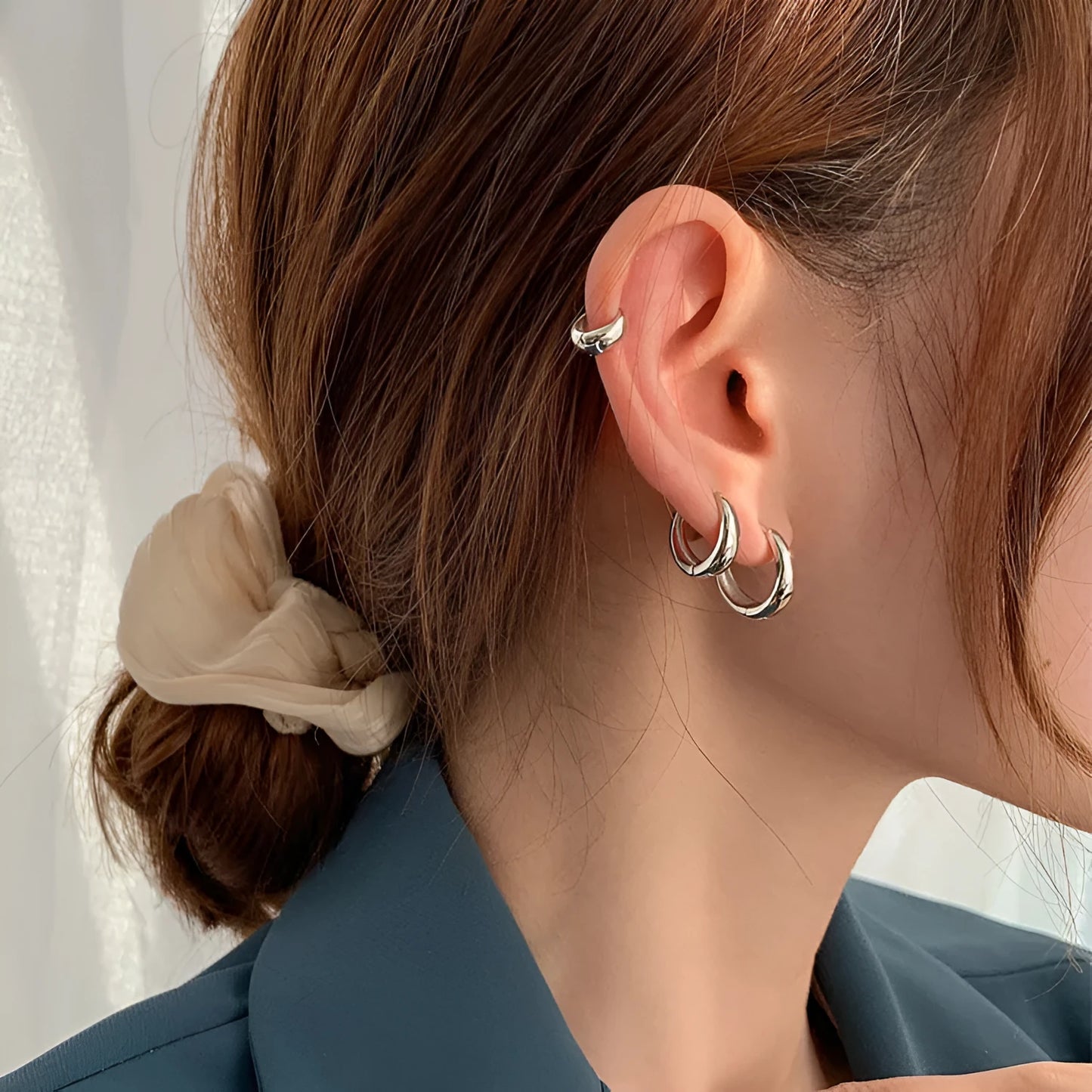 Women's minimalist geometric water drop earrings in gold and silver, shown in large, medium, and small sizes.