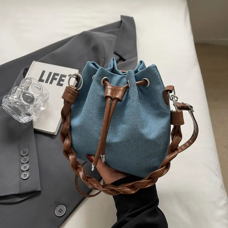 Blue cross body bucket bag with synthetic leather lining and adjustable shoulder strap