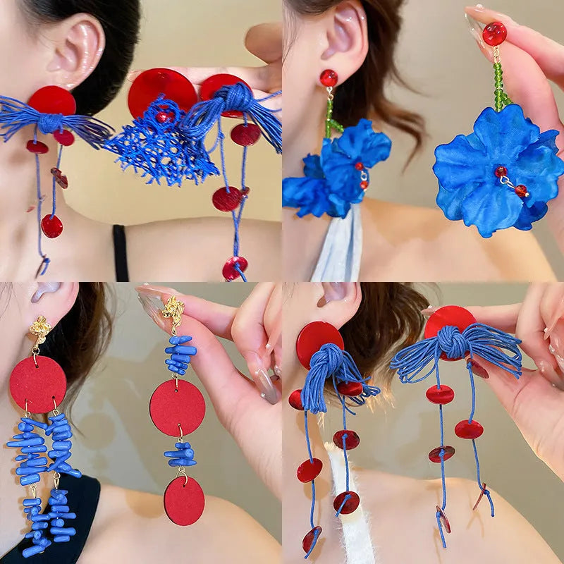 Women's earrings featuring handmade silver needle and blue resin flower design with geometric shapes and round elements, a niche style craft jewellery item made from cloth and resin materials.