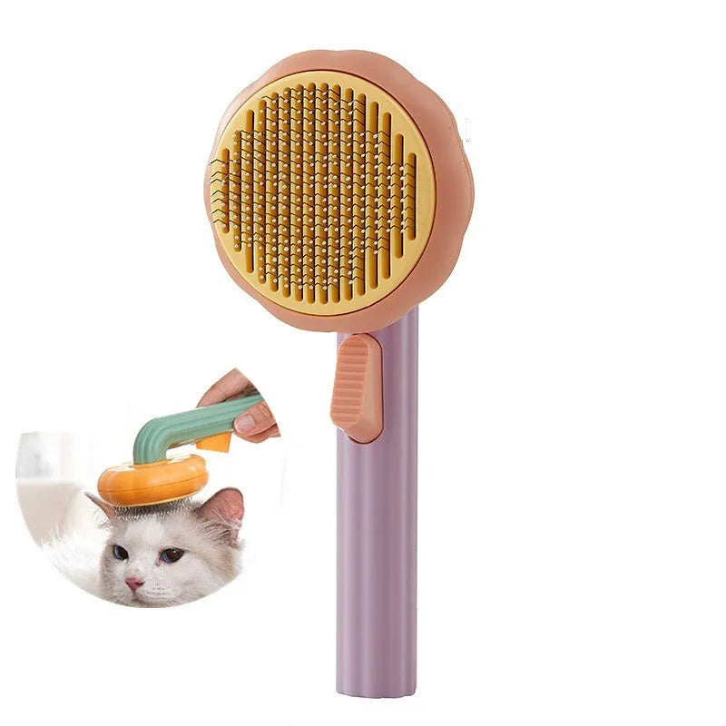 Hand-held pumpkin-coloured pet brush with stainless steel needles for grooming cats and dogs
