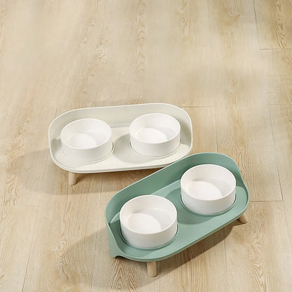 Green tilted pet feeder with adjustable stainless steel frame and two food bowls for cats and dogs