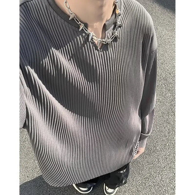 A woman wearing a black and white striped, loose-fit, long-sleeve pullover jumper.