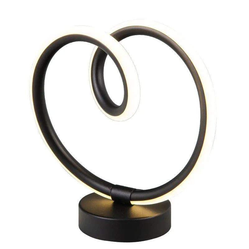 Black remote-controlled LED night light with Bluetooth remote on a bedside table.