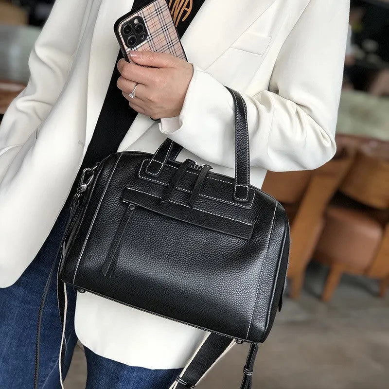 Genuine leather horizontal messenger bag in wine red with shoulder strap and internal zippered compartments.