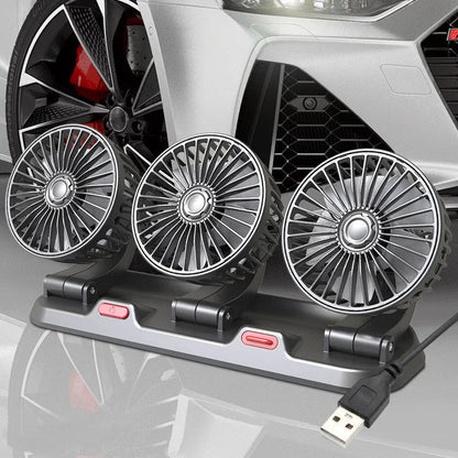 Three-head adjustable 12V car cooling fan with USB and cigarette lighter plugs on a dashboard.