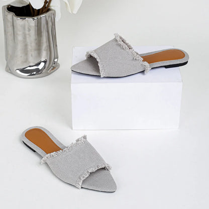 Women's denim flat slippers with tassel detail in apricot colour, showing leather lining.