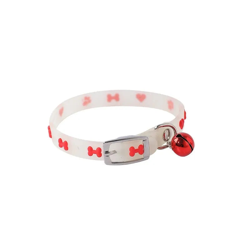 Glowing adjustable luminous collar for cats on a dark background, showing silicone chain and metal bell.