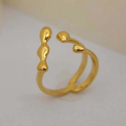 Gold adjustable open ring with spherical details on a woman's hand, showing the 1cm gap.