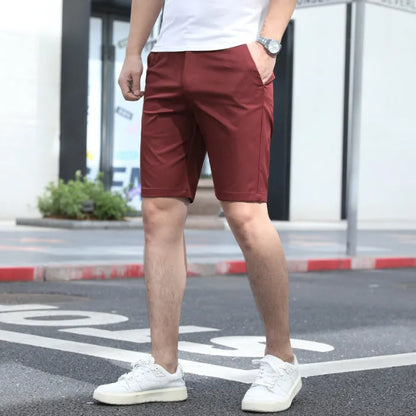 Man wearing loose-fit beige fifth pants with an elastic waistband, showcasing the mid-length casual style.