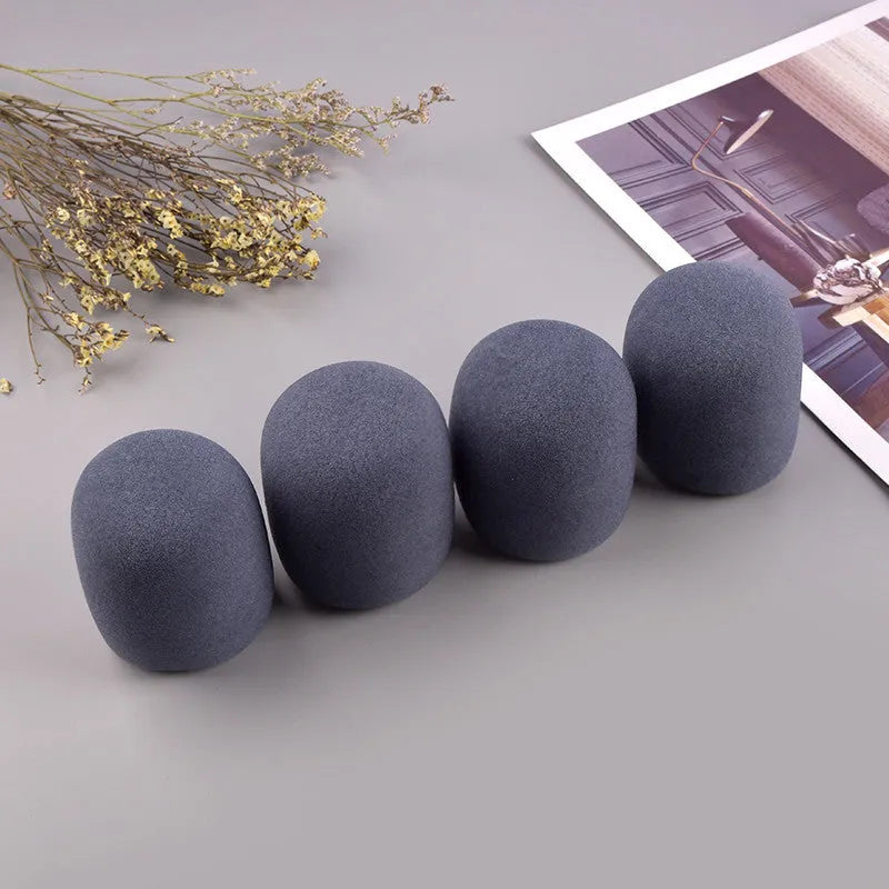Four foam microphone wind shields in different colours for handheld stage microphones