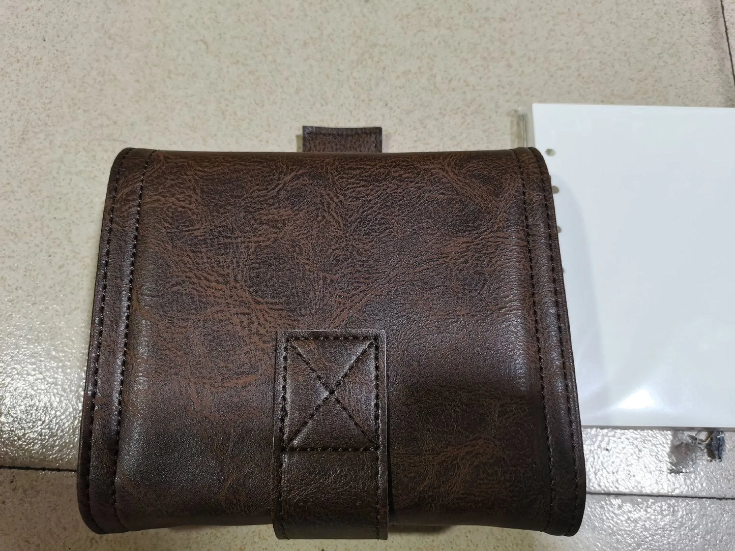Brown A7 loose-leaf notebook with PU cover and retro buckle design, shown open.