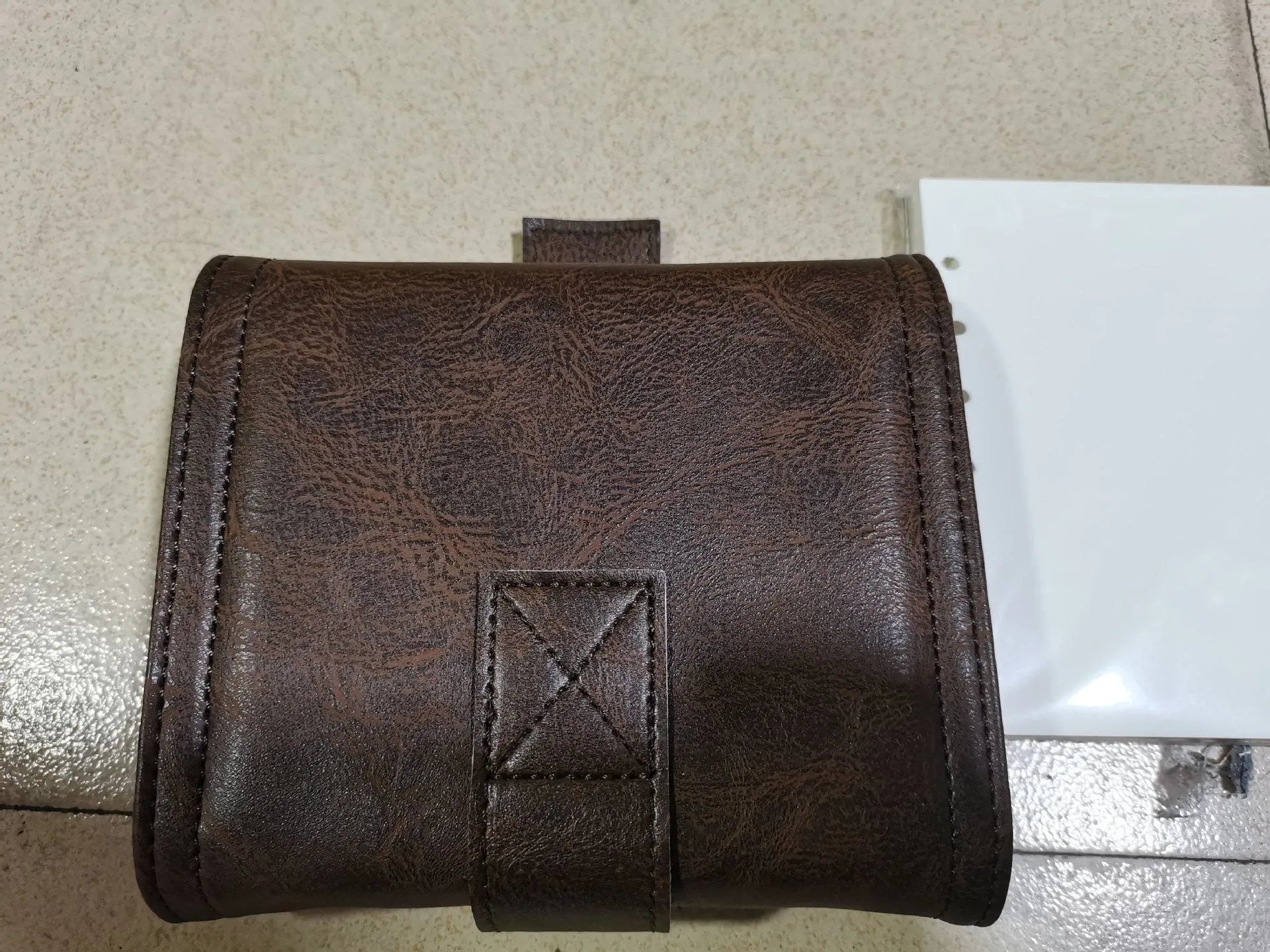 Brown A7 loose-leaf notebook with PU cover and retro buckle design, shown open.